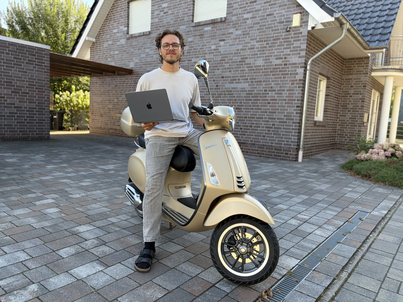 Alex Blank auf einer Vespa mit Laptop in der Hand, unterwegs zu einem Kundentermin rund um Weyhe